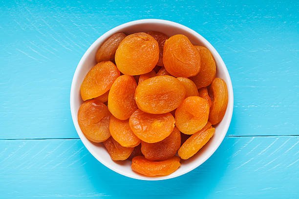 A bowl filled with vibrant orange fruits, showcasing their rich color and natural appeal.