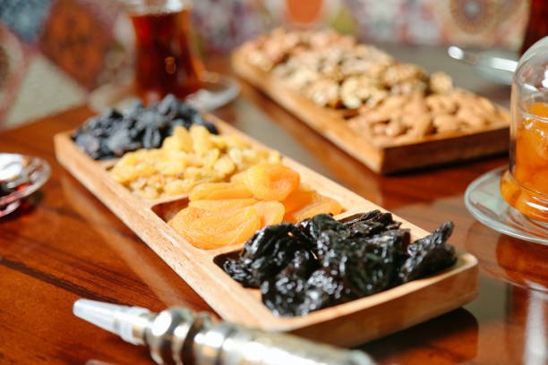 A table displaying an assortment of dried fruits, including apricot dry fruit and nut energy bars.
