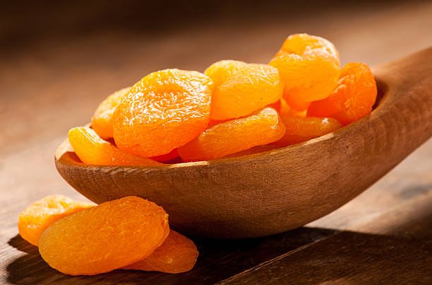 Dried apricots in a hand made wooden spoon