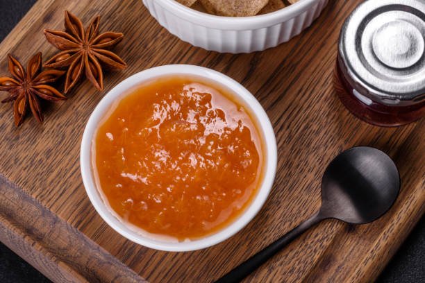 A vibrant display of chips, salsa, and star anise, accompanied by a jar of spiced apricot dry fruit chutney.
