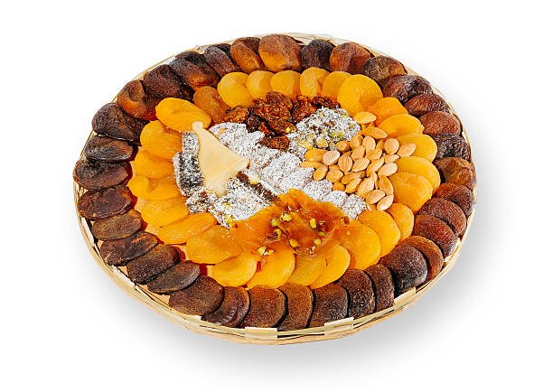 A round basket overflowing with an assortment of dried fruits and nuts, showcasing vibrant colors and textures.