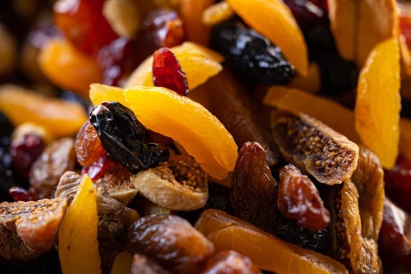 A close-up view of an assortment of apricot dry fruit and nuts, showcasing their textures and vibrant colors.