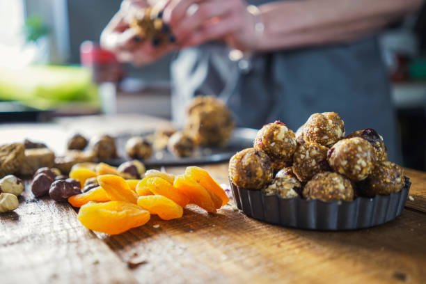 A woman presents a tray filled with an assortment of nuts and dried fruit, showcasing a healthy snack option.