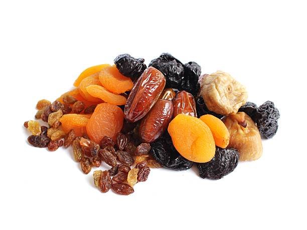 A variety of dried fruits and nuts arranged on a clean white background, showcasing their natural colors and textures.