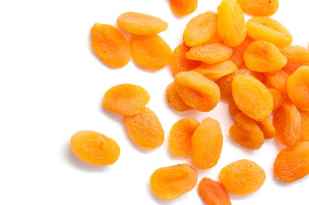 A collection of dried apricots arranged on a white background, showcasing their rich orange color and wrinkled texture.