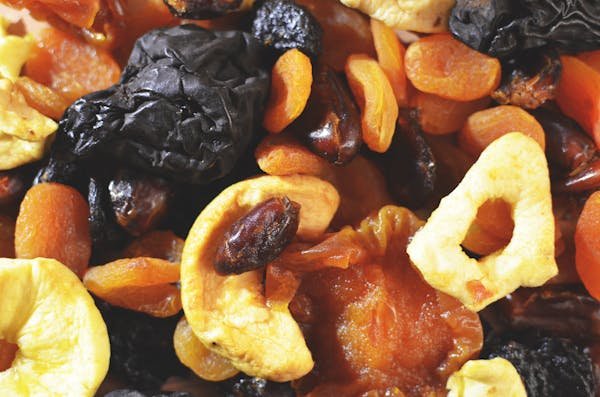 A close-up view of an assortment of dried apricots with other dry fruits and nuts, showcasing their textures and vibrant colors.