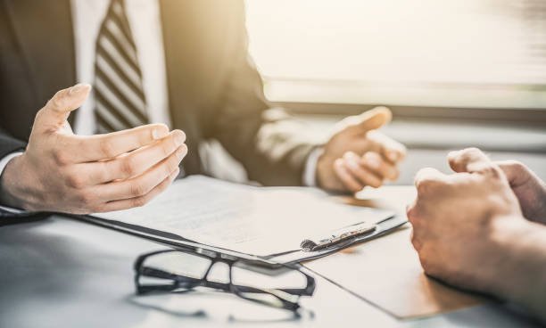 Two business professionals engaged in a discussion at a desk, focusing on auto insurance matters.