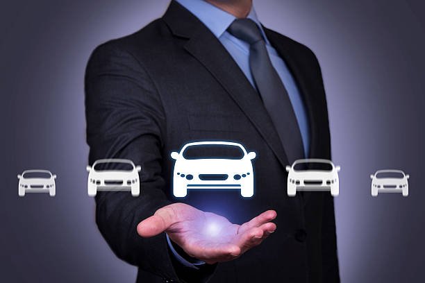 a man in a suit holding a car icon